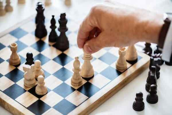 Black and white chessboard with a hand moving a piece