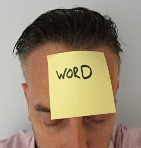Word on head Post-it note with word written stuck to a man's head