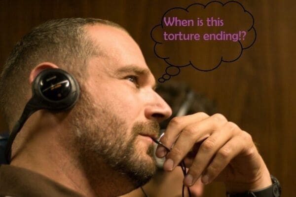 Man wearing headphones thinking When is this torture ending? inside a speech bubble