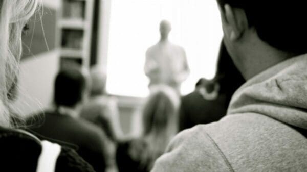 Back view of people at a lecture and blurred presenter