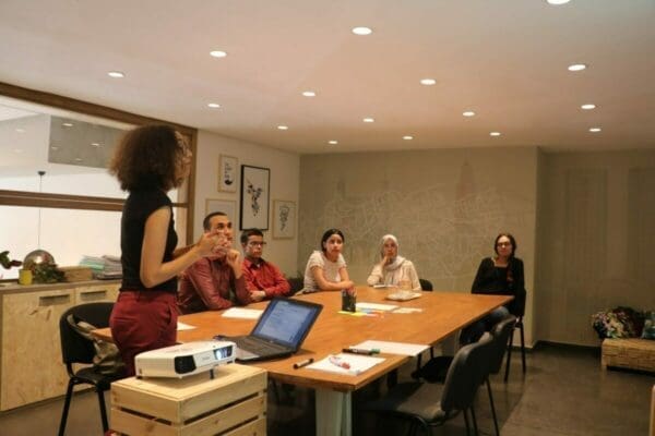 Female manager presenting to a group of colleagues around a table