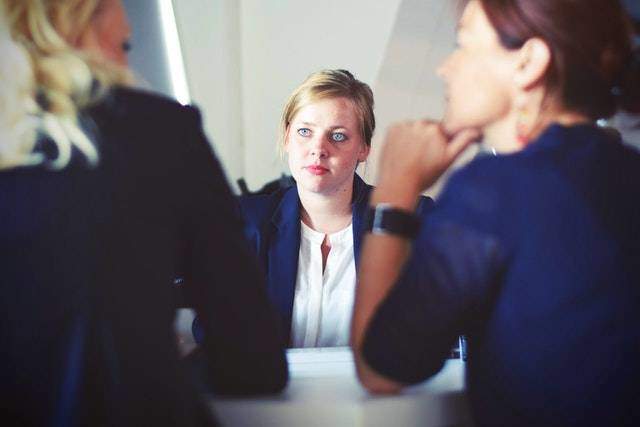 Woman observing two women talking Woman observing two women talking during negotiation