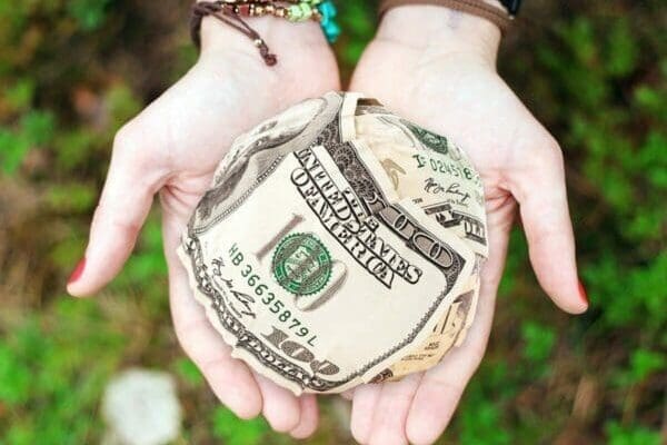 Ball of USD dollars in the hand of recruitment agency fee collector