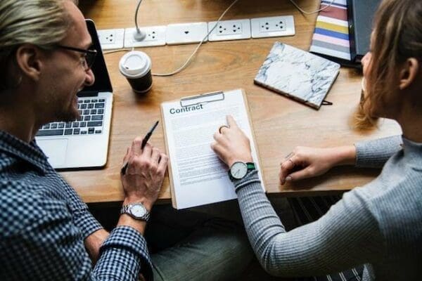 Account manager using negotiation technique with coworker reviewing a document