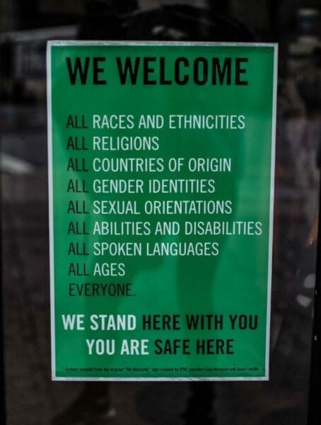 Green poster titled We Welcome to encourage inclusivity and equality