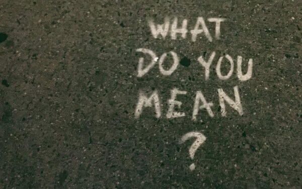 Concrete pavement with 'What Do You Mean?' chalked on it