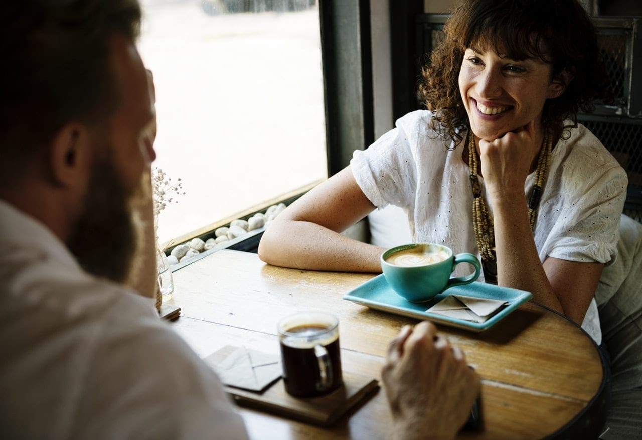 A conversation over coffee A man and woman having a conversation over coffee at a cafe to improve mental health
