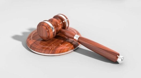 A wooden gavel resting on its wooden base