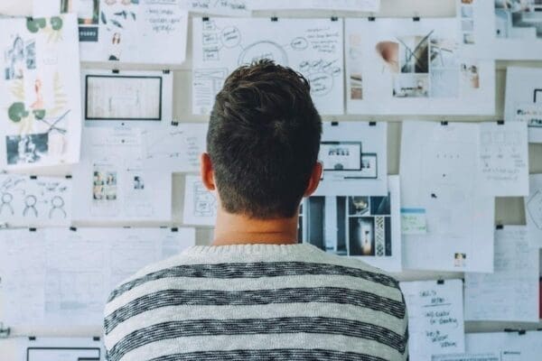 Man looking at wall full of drawings and pictures