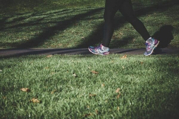 Woman in gym clothes walking alongside a pavement