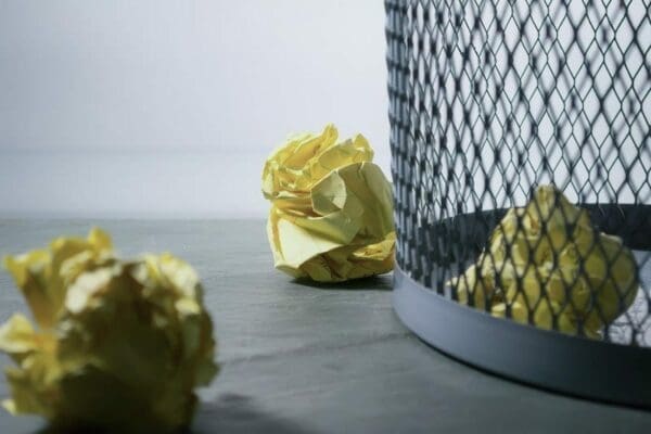 Two crumpled paper and crumpled paper in a wastepaper bin