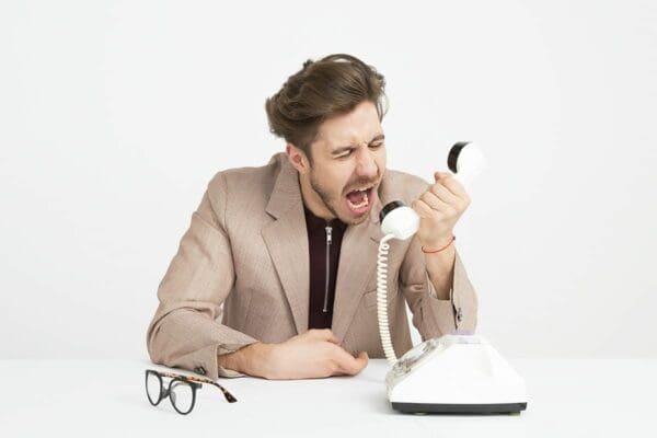 Man shouting Businessman shouting into a white telephone