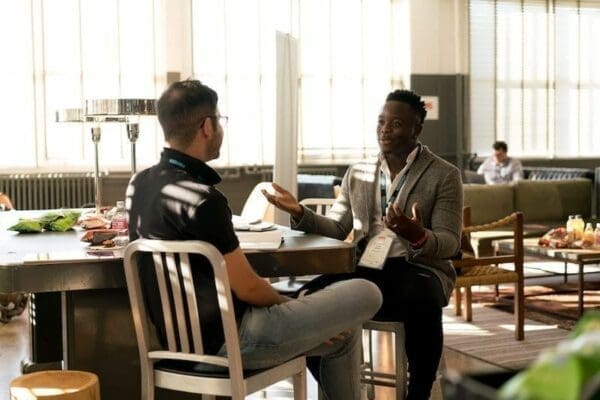 Two people sitting on their respective chairs, having a conversation