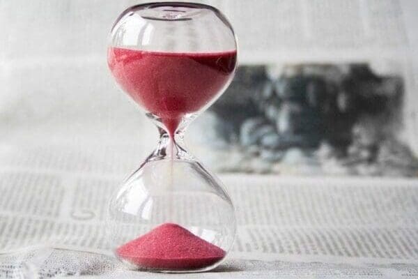 Clear hourglass with red sand for time management tips