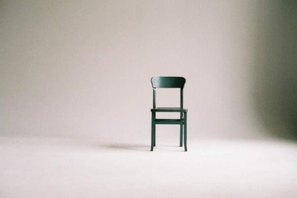 Simple green chair in a white room