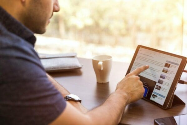 A man scrolling on his laptop, looking at trade communications