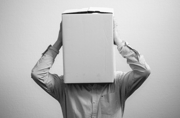 Black and white picture of a man with a white cardboard box over his head