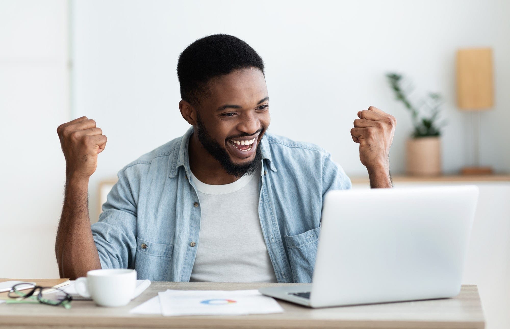 Enthusiastic businessman looking at his laptop