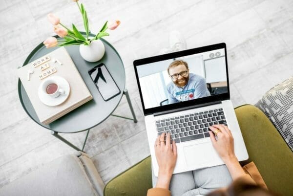 Business woman having a video call with coworker as she works from home