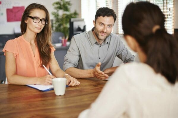 Male and female HR managers interviewing a woman candidate for a job