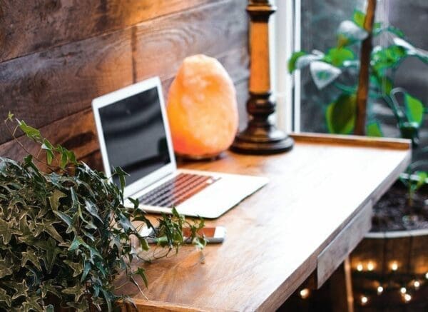 Home working area featuring a wooden table with a laptop 