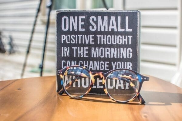 Plaque with positive quote and glasses in front 
