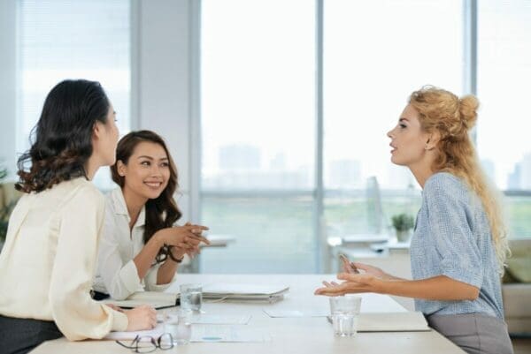 Three female co-workers involved in a negotiation