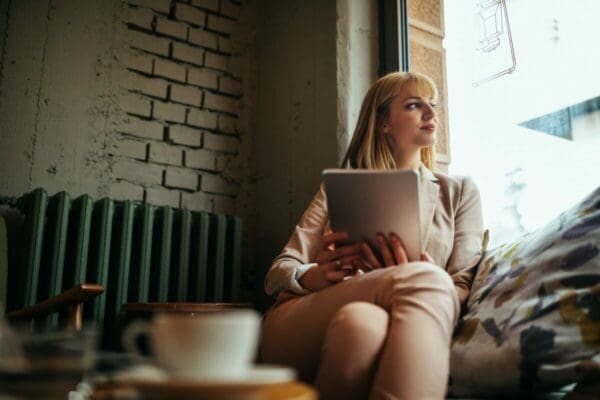 Woman at a coffee shop looking out of the window as she waits 