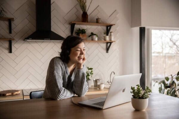 Woman at home desk on a video call and smiling 