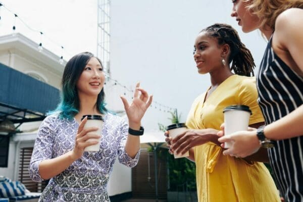 Woman telling two female colleagues how to talk to anyone