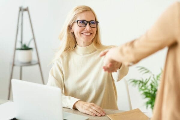 Smiling female HR shaking hand with a past job applicant