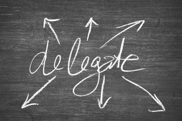 Delegate written on chalkboard with arrows pointing away from it