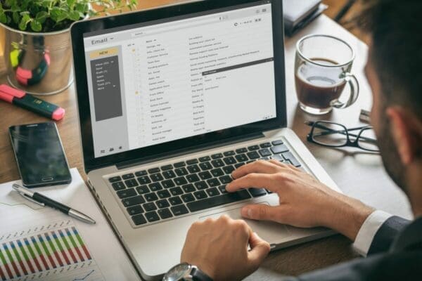 A businessman practicing time management for his emails using his laptop