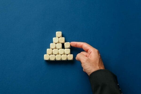 Business executive building a pyramid shape with wooden dices