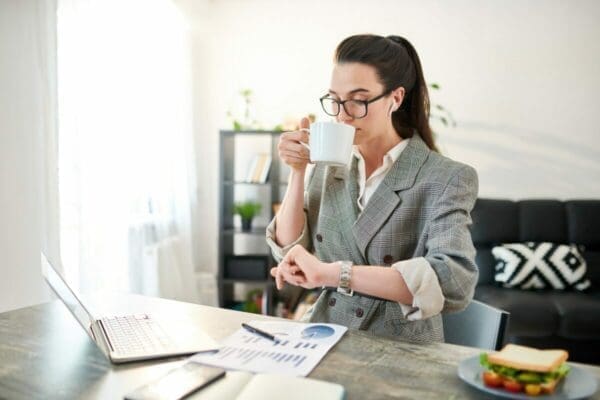 Buinesswoman Checking Time and drinking coffee