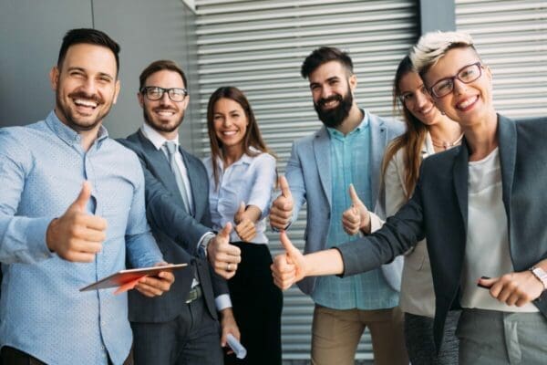 Happy smiling group of workers giving a thumbs up