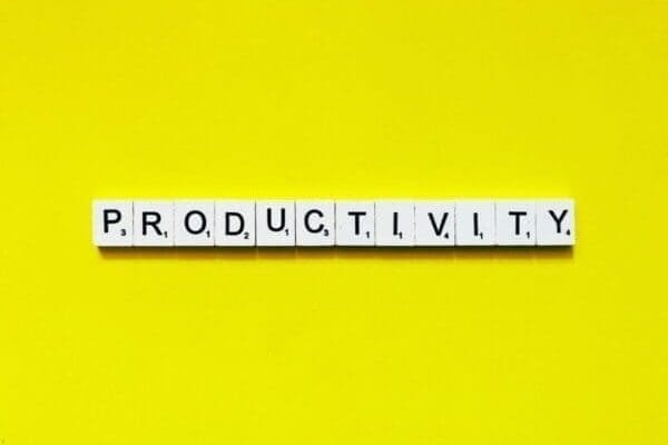 Productivity spelled with scrabble tiles on yellow background