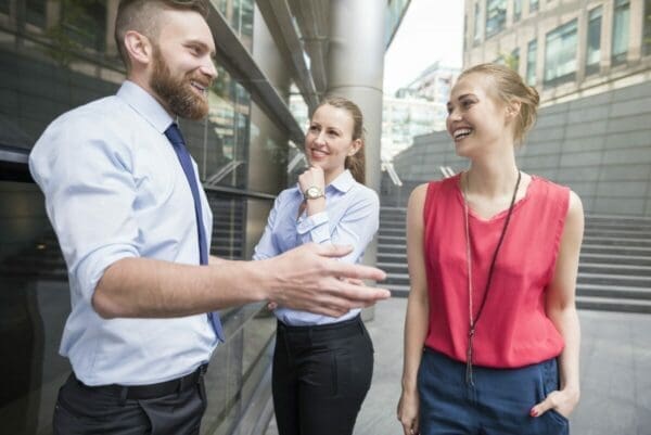 Male and two female colleagues having a discussion outside