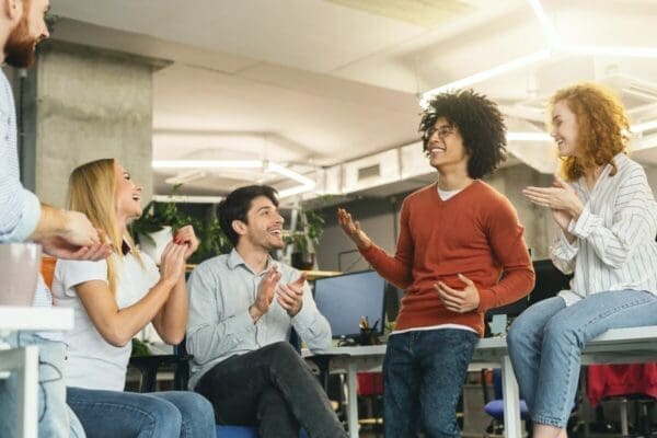 Happy group Group of colleagues having a conversation in the office and looking happy showing great interpersonal skills