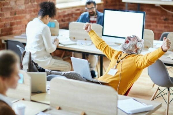 Businessman in office throwing hands in the air is enthusiastic