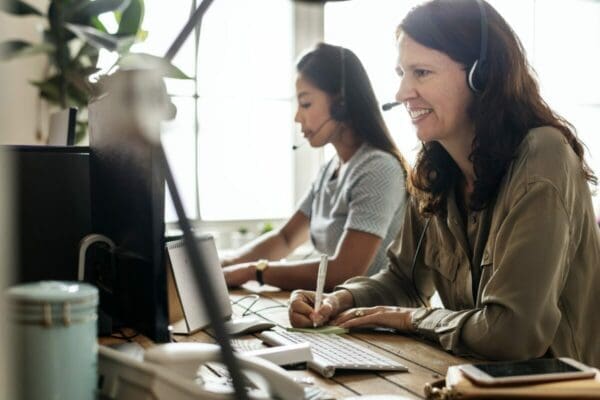 Female account manager on a video call taking notes