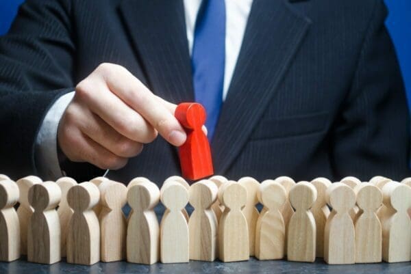 Businessman picking out the red wooden figure for best talent