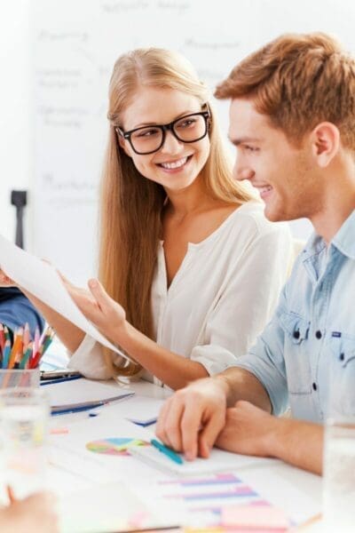 Two colleagues at a desk sharing information