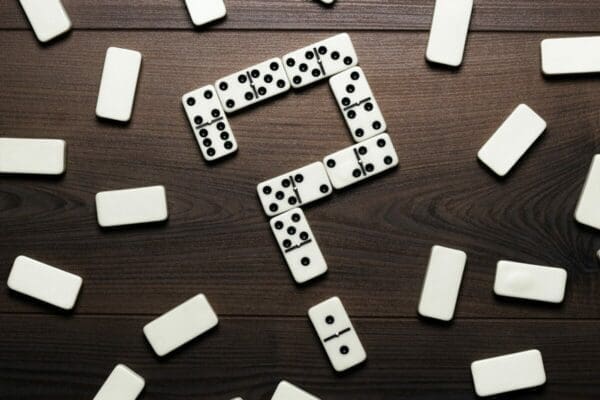 Domino Pieces Forming Question Mark On Wooden Table