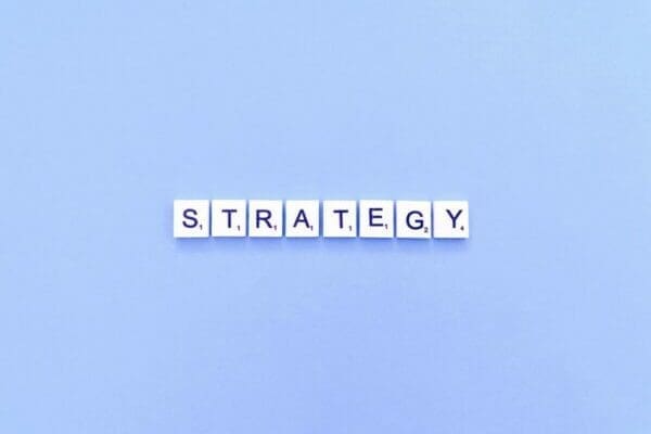 Strategy spelled with word scramble tiles on light blue background