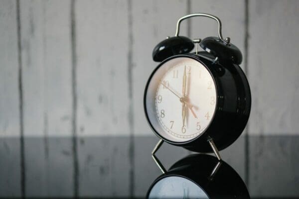 Black alarm clock on a reflective surface