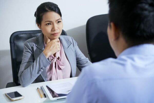 Manager talking to male employee across a desk