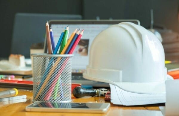 Safety at work Multi colored pencils in box with safety helmet