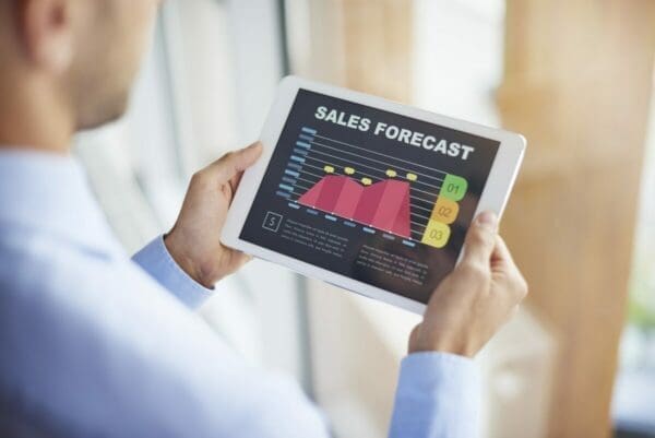 Businessman looking at sales forecast on digital tablet to increase profits