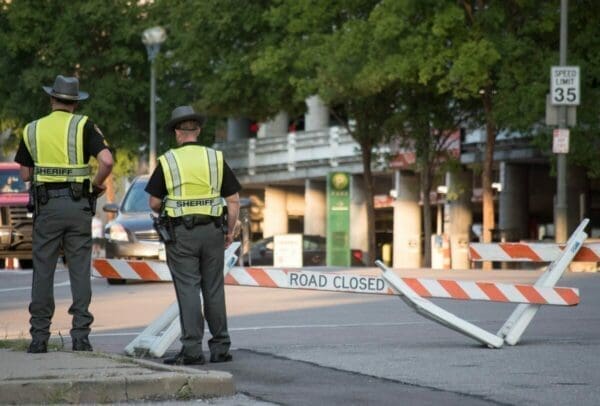 Two policeman next to a roadblock